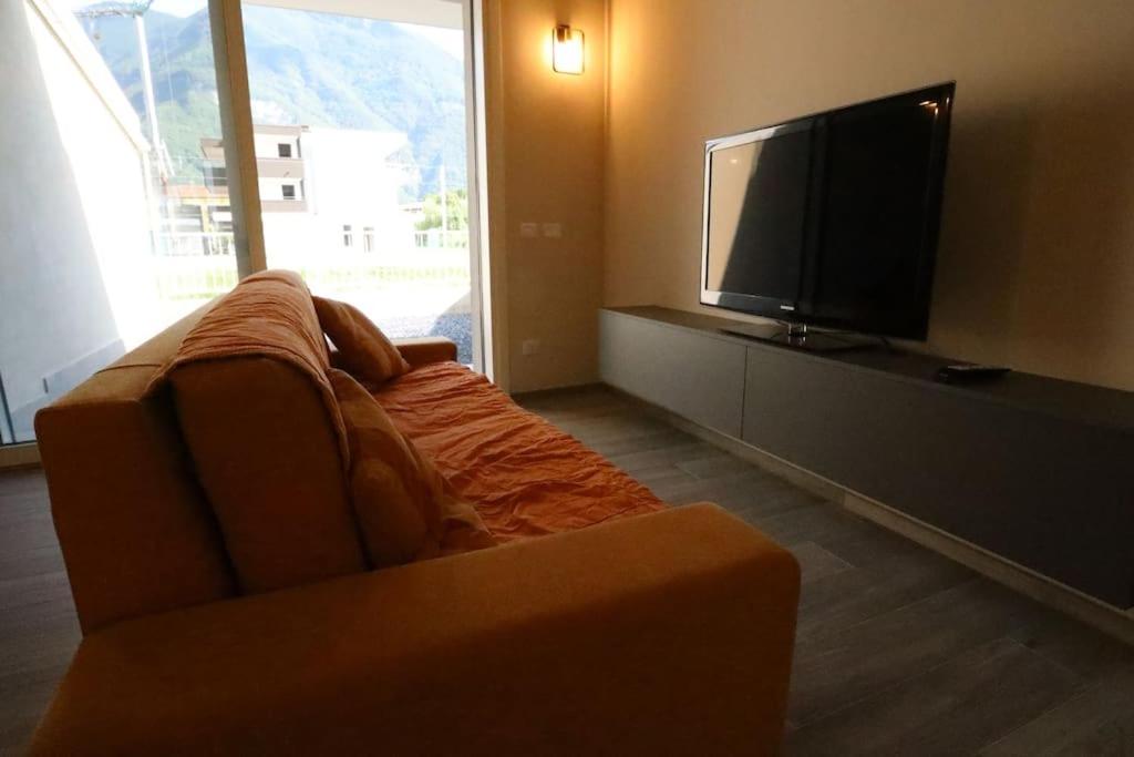 Divano Letto e TV a schermo piatto con telecomando.